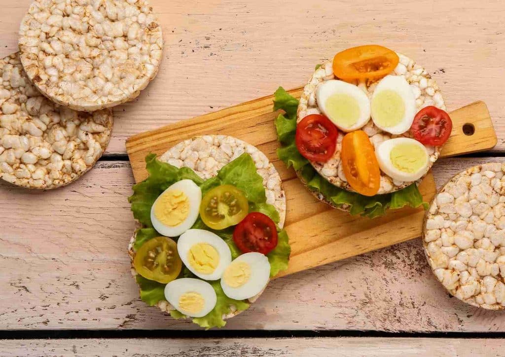 Easy Meals for Weight Loss When You're Short on Time 11 A plate featuring rice, fried eggs, tomatoes, and assorted vegetables arranged attractively.