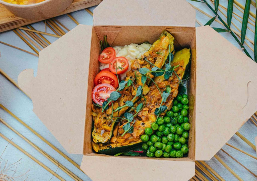 Easy Meals for Weight Loss When You're Short on Time 10 A box containing assorted food items alongside a bowl of white rice on a wooden surface.