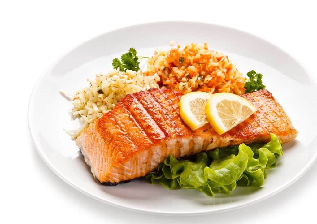 Easy Meals for Weight Loss When You're Short on Time 12 A plate featuring grilled salmon, steamed rice, and a medley of colourful vegetables arranged artfully.