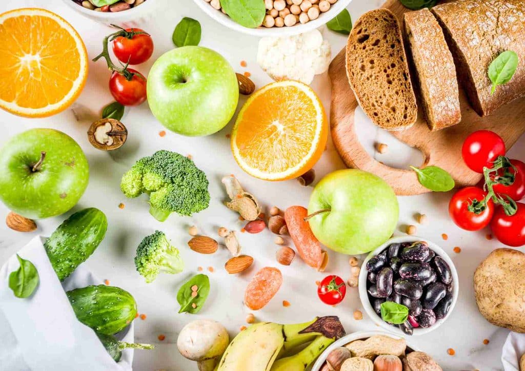 Postpartum Weight Loss: A Gentle, Realistic Guide 20 An assortment of fresh fruits, vegetables, and nuts arranged in bowls, showcasing vibrant colours and textures.