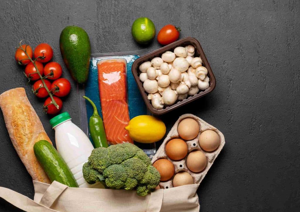 What Is a Balanced Diet for Weight Loss? 15 A grocery bag filled with fresh vegetables, eggs, and assorted food items, showcasing a healthy selection of groceries.