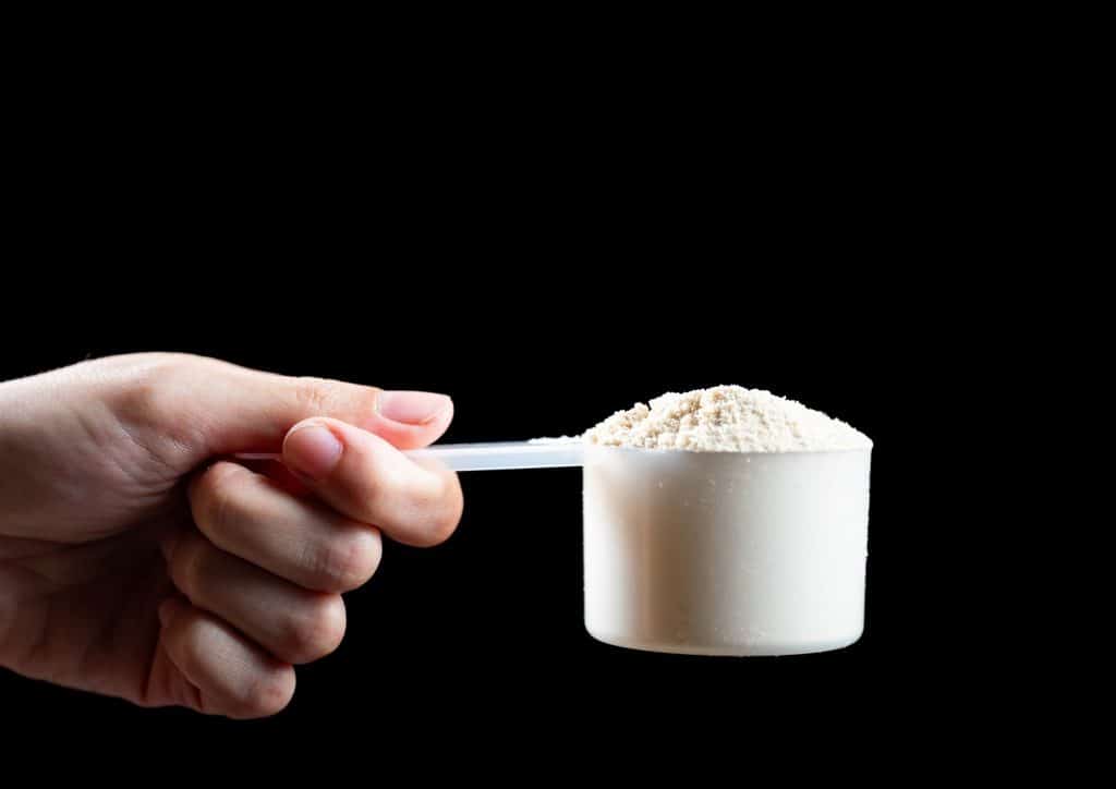 Is Whey Protein Good for Weight Loss? 11 A person holds a scoop of powder in their hand, showcasing the texture and quantity of the substance.