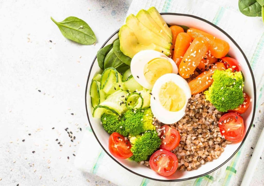 Healthy Dinners for Weight Loss: Easy Weeknight Ideas 37 A bowl filled with assorted vegetables, raw eggs, and a hard-boiled egg on top.