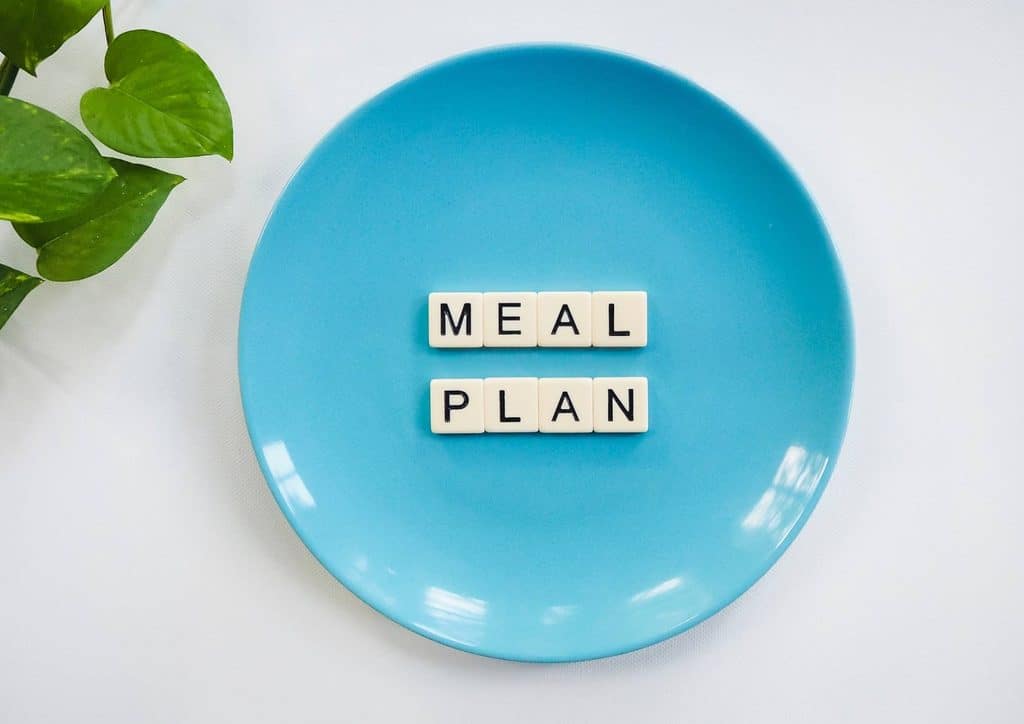 Healthy Meal Plans for Weight Loss: How to Build One That Lasts 30 A blue plate featuring a word block that spells out "meal plan" in bold letters.