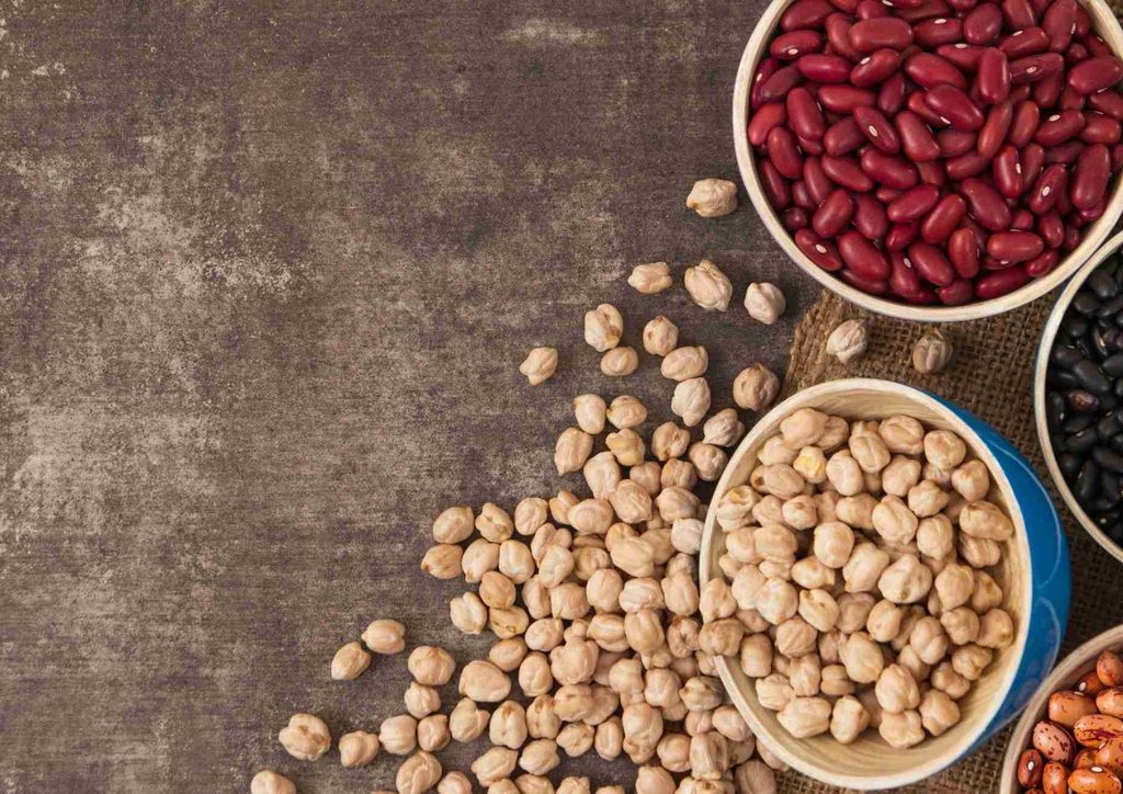 High Fibre Diet for Weight Loss: Why Fibre Keeps You Full 9 An assortment of beans, including black, kidney, and pinto, arranged neatly on a wooden surface.
