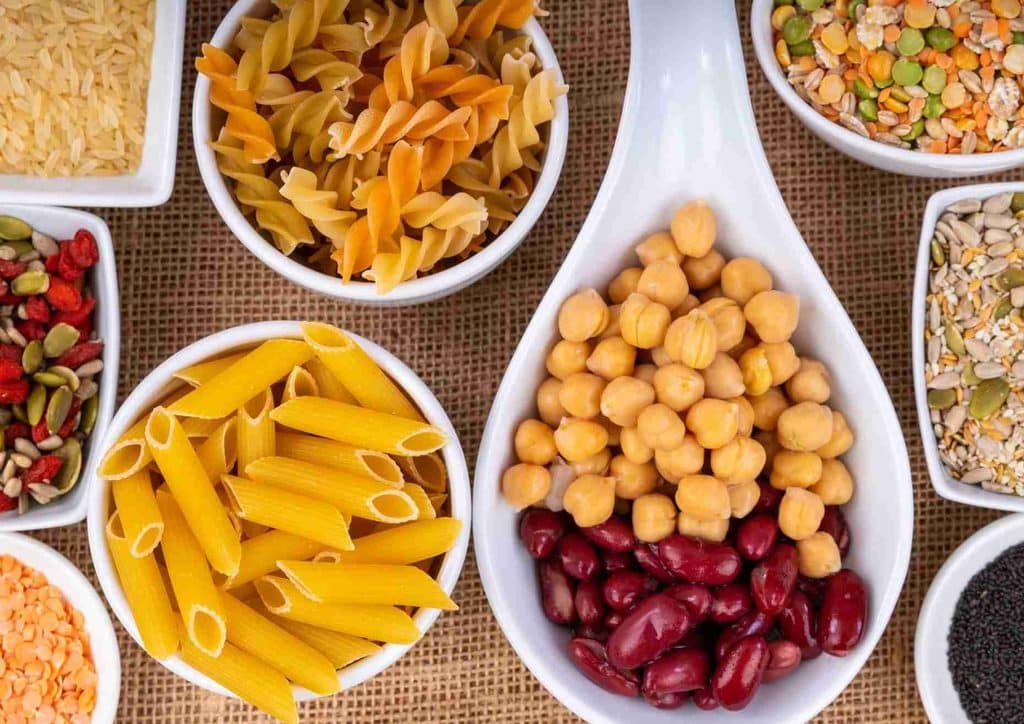 High Fibre Diet for Weight Loss: Why Fibre Keeps You Full 11 Assorted bowls filled with different types of pasta, beans, and other ingredients arranged aesthetically.
